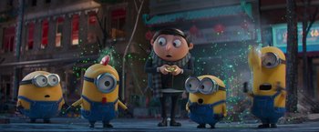 Movie still from “Minions: The Rise of Gru” (2022), directed by Jonathan del Val – A group of minions standing next to each other in front of a person; Medium shot, Over the shoulder angle