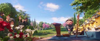 Movie still from “Minions: The Rise of Gru” (2022), directed by Jonathan del Val – An image of an animated character standing in front of a podium; Wide shot, Low angle