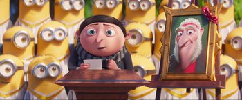 Movie still from “Minions: The Rise of Gru” (2022), directed by Jonathan del Val – A man sitting at a table holding a piece of paper; Medium shot, Over the shoulder angle