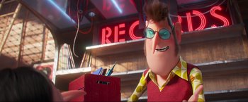 Movie still from “Minions: The Rise of Gru” (2022), directed by Jonathan del Val – A man with a box of pencils in front of a neon sign; Medium shot, Over the shoulder angle