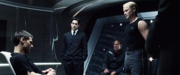 Movie still from “Minority Report” (2002), directed by Steven Spielberg – A group of men standing next to each other in suits; Medium shot, Over the shoulder angle