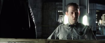 Movie still from “Minority Report” (2002), directed by Steven Spielberg – A man wearing a bow tie sitting at a table; Close Up shot, Over the shoulder angle