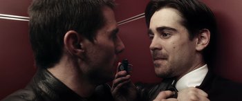 Movie still from “Minority Report” (2002), directed by Steven Spielberg – Two men one of whom is holding a cell phone in his ear; Close Up shot, Over the shoulder angle