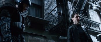Movie still from “Minority Report” (2002), directed by Steven Spielberg – A building that has a fire hydrant on the side of it; Wide shot, Low angle