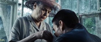 Movie still from “Minority Report” (2002), directed by Steven Spielberg – An older woman putting something on a younger man's collar; Close Up shot, Low angle