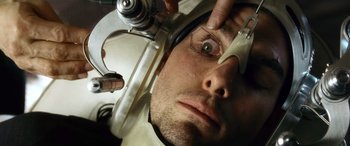 Movie still from “Minority Report” (2002), directed by Steven Spielberg – A man wearing a space helmet looking into a mirror; Extreme Close Up shot, Overhead angle