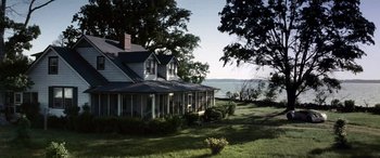 Movie still from “Minority Report” (2002), directed by Steven Spielberg – A house with a porch sitting next to a body of water; Extreme Wide shot, High angle