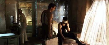 Movie still from “Minority Report” (2002), directed by Steven Spielberg – Two men are sitting in a room and one is holding a briefcase; Medium shot, Low angle