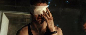 Movie still from “Minority Report” (2002), directed by Steven Spielberg – A blindfolded man holding his hand up to his face; Close Up shot, Over the shoulder angle