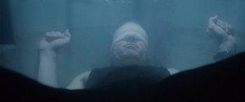 Movie still from “Minority Report” (2002), directed by Steven Spielberg – A man with bandages on his head is submerged in water; Close Up shot, Overhead angle