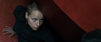 Movie still from “Minority Report” (2002), directed by Steven Spielberg – A woman with blue eyes hiding behind a red wall; Close Up shot, Overhead angle