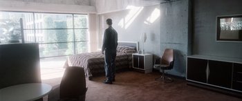 Movie still from “Minority Report” (2002), directed by Steven Spielberg – A man standing in front of a bed in a room; Wide shot, High angle