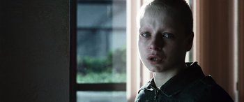 Movie still from “Minority Report” (2002), directed by Steven Spielberg – A young boy with a shaved head is looking at the camera; Close Up shot, Over the shoulder angle