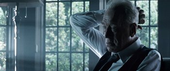 Movie still from “Minority Report” (2002), directed by Steven Spielberg – An older man leaning against a wall with his hands behind his head; Close Up shot, Low angle