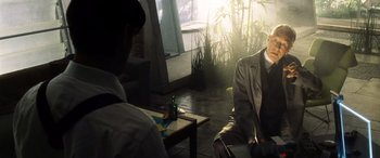 Movie still from “Minority Report” (2002), directed by Steven Spielberg – A man sitting on a chair next to a table; Medium shot, Over the shoulder angle