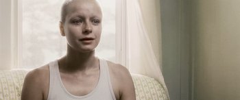 Movie still from “Minority Report” (2002), directed by Steven Spielberg – A woman in a white tank top is sitting on a couch; Close Up shot, Over the shoulder angle
