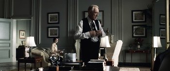 Movie still from “Minority Report” (2002), directed by Steven Spielberg – An older man standing in front of a table; Medium shot, Over the shoulder angle