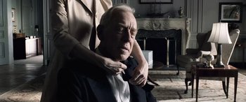 Movie still from “Minority Report” (2002), directed by Steven Spielberg – An older man wearing a suit and a tie; Close Up shot, Over the shoulder angle