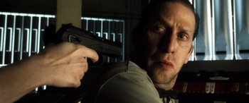 Movie still from “Minority Report” (2002), directed by Steven Spielberg – A person holding a gun in a room; Close Up shot, Over the shoulder angle