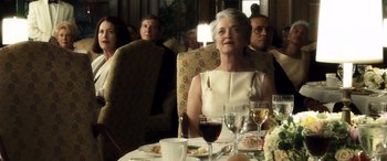 Movie still from “Minority Report” (2002), directed by Steven Spielberg – An older woman sitting at a dinner table with wine glasses; Medium shot, Over the shoulder angle
