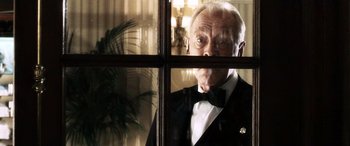 Movie still from “Minority Report” (2002), directed by Steven Spielberg – An older man in a tuxedo looking out of a window; Close Up shot, Low angle