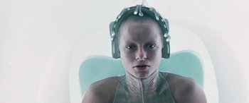 Movie still from “Minority Report” (2002), directed by Steven Spielberg – A woman with a headset on sitting in a chair; Close Up shot, Overhead angle