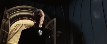 Movie still from “Minority Report” (2002), directed by Steven Spielberg – An older man in a tuxedo standing next to a wall; Close Up shot, Low angle