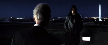 Movie still from “Minority Report” (2002), directed by Steven Spielberg – A man in a black hooded jacket and a man in a black suit; Medium shot, Over the shoulder angle
