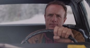Movie still from “Misery” (1990), directed by Rob Reiner – A person in a car holding a steering wheel; Close Up shot, Low angle