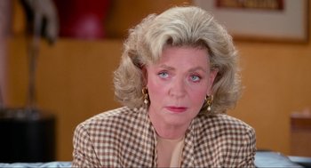 Movie still from “Misery” (1990), directed by Rob Reiner – An older woman with blonde hair wearing a checkered jacket; Close Up shot, Over the shoulder angle