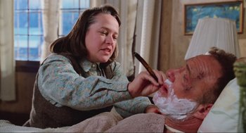 Movie still from “Misery” (1990), directed by Rob Reiner – A woman shaving a man's face with a wooden stick; Close Up shot, Over the shoulder angle
