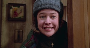 Movie still from “Misery” (1990), directed by Rob Reiner – A person wearing a hat with a cross on it; Close Up shot, Low angle