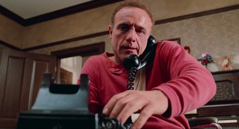 Movie still from “Misery” (1990), directed by Rob Reiner – A man sitting in front of an old fashioned phone; Close Up shot, Low angle