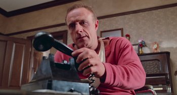 Movie still from “Misery” (1990), directed by Rob Reiner – A man holding a phone up to his ear; Close Up shot, Low angle