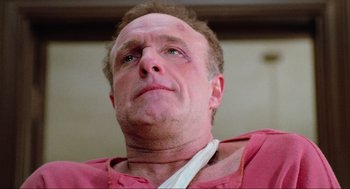 Movie still from “Misery” (1990), directed by Rob Reiner – A person wearing a pink shirt; Close Up shot, Low angle