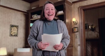 Movie still from “Misery” (1990), directed by Rob Reiner – A woman holding a piece of paper in her hands; Medium shot, Low angle