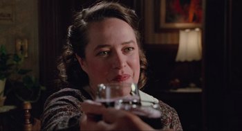 Movie still from “Misery” (1990), directed by Rob Reiner – A woman is holding a wine glass in her hand; Close Up shot, Over the shoulder angle