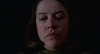 Movie still from “Misery” (1990), directed by Rob Reiner – A woman's face in the dark; Close Up shot, Low angle