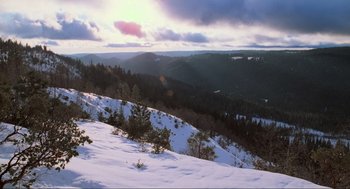 Movie still from “Misery” (1990), directed by Rob Reiner – A view of a mountain range with snow on the ground; Extreme Wide shot, High angle
