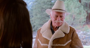 Movie still from “Misery” (1990), directed by Rob Reiner – An older man wearing a hat and a coat; Medium shot, Over the shoulder angle