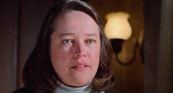Movie still from “Misery” (1990), directed by Rob Reiner – A woman's face in front of a lamp; Close Up shot, Low angle