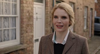 A woman wearing a jacket and a sweater