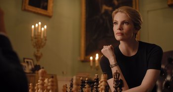 A woman sitting in front of a chessboard