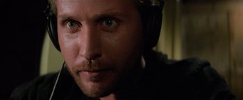 Movie still from “Mission: Impossible” (1996), directed by Brian De Palma – A person wearing headphones; Close Up shot, Over the shoulder angle