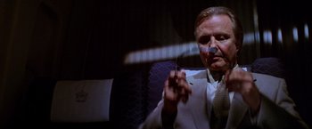 Movie still from “Mission: Impossible” (1996), directed by Brian De Palma – A man in a white jacket holding a knife; Close Up shot, Low angle