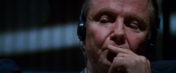 Movie still from “Mission: Impossible” (1996), directed by Brian De Palma – An older man wearing a headset with one hand to his mouth; Close Up shot, Low angle