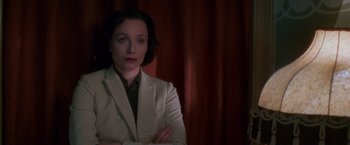 Movie still from “Mission: Impossible” (1996), directed by Brian De Palma – A woman in a white jacket is posing for a picture; Close Up shot, Low angle