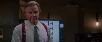 Movie still from “Mission: Impossible” (1996), directed by Brian De Palma – An older man wearing a tie standing in front of a computer screen; Close Up shot, Low angle