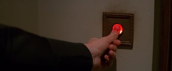Movie still from “Mission: Impossible” (1996), directed by Brian De Palma – A person is holding a button to turn on a light; Extreme Close Up shot, High angle