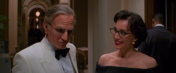 Movie still from “Mission: Impossible” (1996), directed by Brian De Palma – A man and a woman wearing glasses and a tuxedo; Close Up shot, Over the shoulder angle